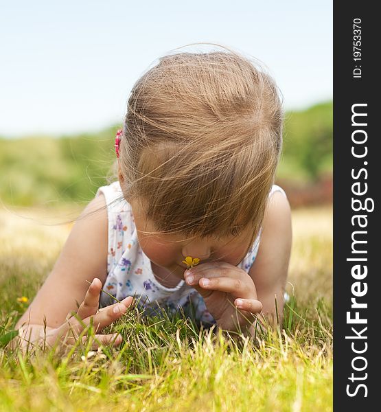 Little girl olfact flower and lying on grass in the park. Little girl olfact flower and lying on grass in the park