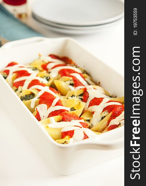 Stuffed pasta shells in white baking dish. Stuffed pasta shells in white baking dish