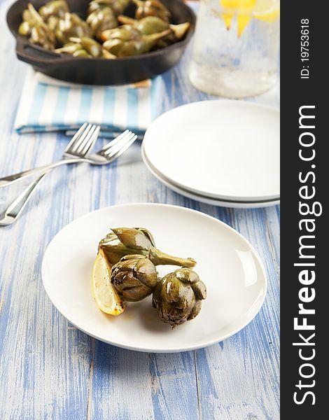 Baby artichokes roasted simply and served with lemon. Baby artichokes roasted simply and served with lemon