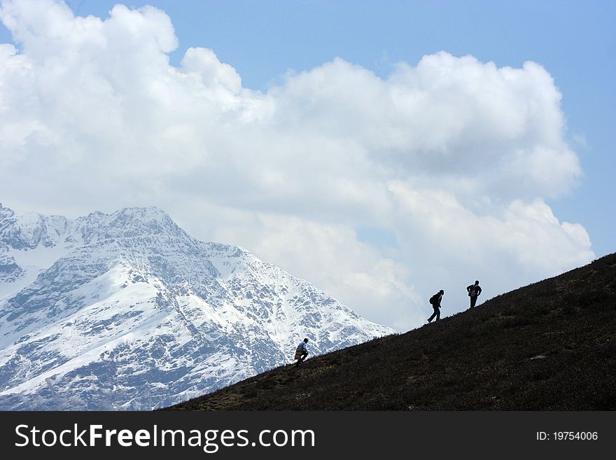 Trekkers at Chandrasila, a place at Himalayas, are climbing to visit hill top and enjoying the heavenly beauty. Trekkers at Chandrasila, a place at Himalayas, are climbing to visit hill top and enjoying the heavenly beauty