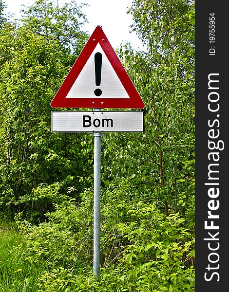 A Norwegian warning sign, with white background, red borders and black letters, with the Norwegian word Bom which means that there is a passage where the road might be closed. A Norwegian warning sign, with white background, red borders and black letters, with the Norwegian word Bom which means that there is a passage where the road might be closed.