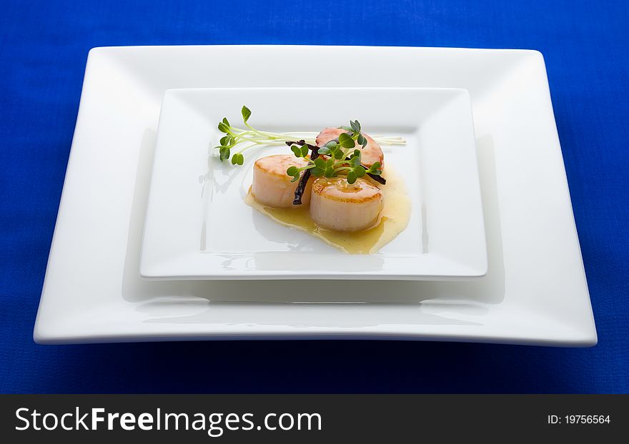 Scallop seafood appetizer with vanilla stick and sauce.