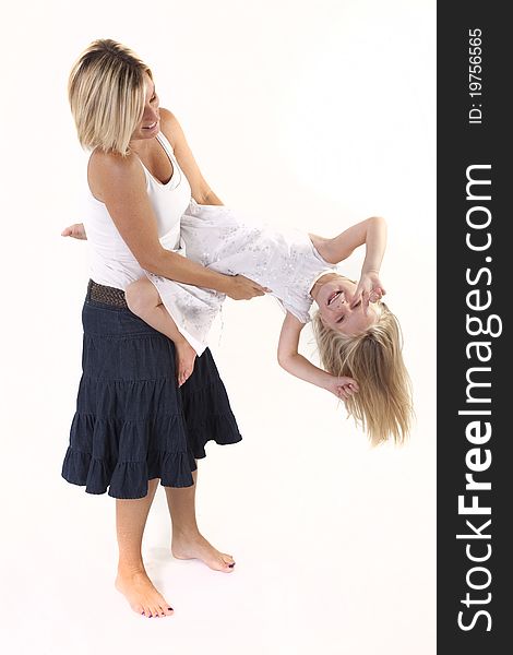 Blonde mother and daughter playing around in studio.