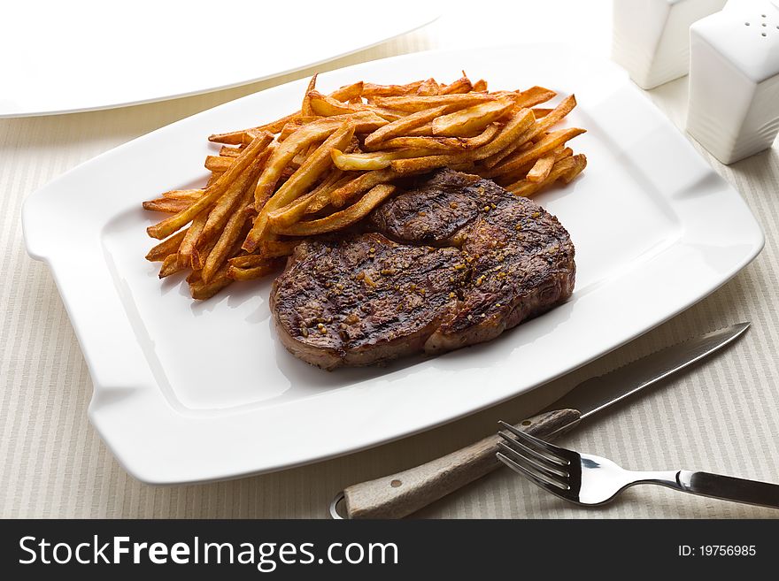 Steak frite (french frie) in a white plate.