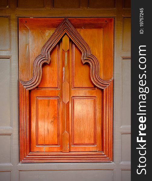 Thai style wooden temple window on brown wall. Thai style wooden temple window on brown wall