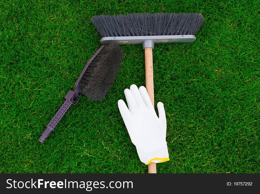 Brushes and a glove on a green grass.