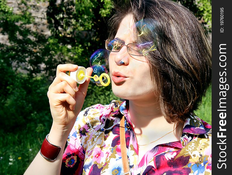 Young beautiful girl blowing bubbles in the nature. Young beautiful girl blowing bubbles in the nature