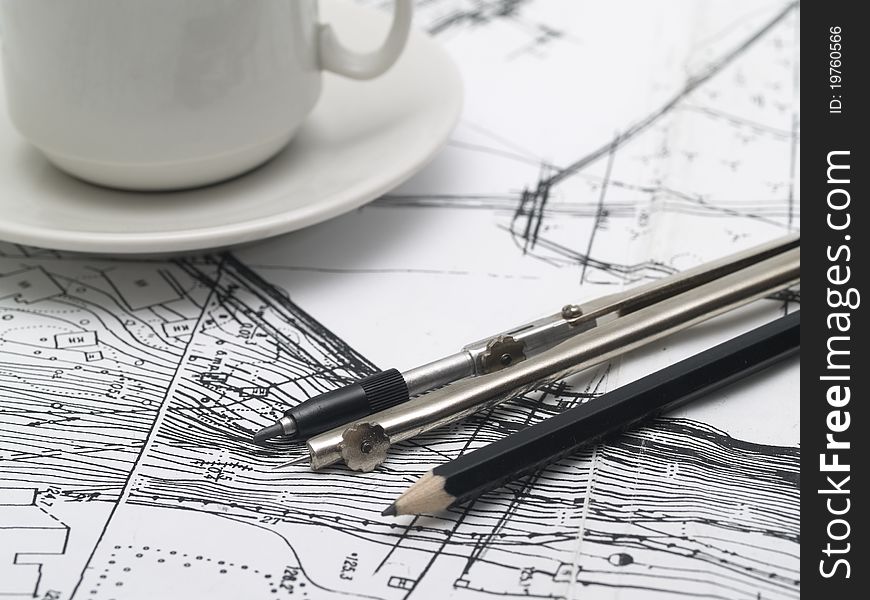 Drawing of the architectural site plan, drawing instruments and cup of coffee
