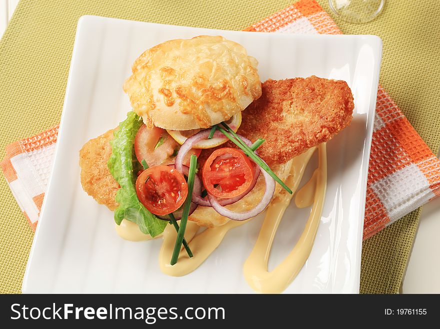 Fried fish sandwich with vegetable garnish and mayonnaise