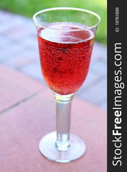 Sweet raspberry soda in a transparent glass on the terrace