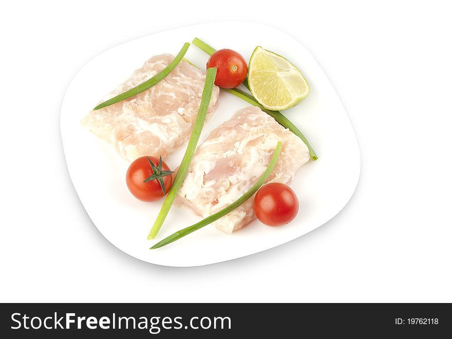 Pangasius fillet molded, decorated with cherry tomatoes with lime and green onions on a white plate