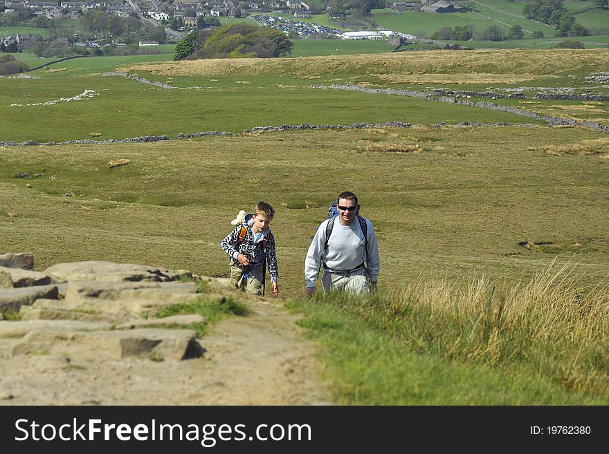 Active Father & Son Hiking On Hill In Countryside