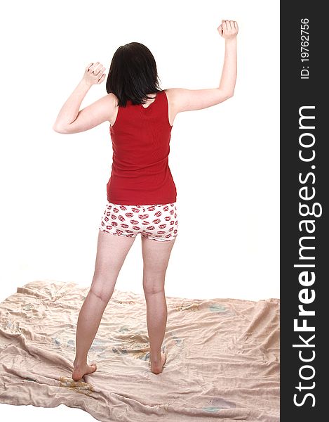 A lovely young woman is stretching after a good night sleep, standing on her comforter in night wear shorts, for white background. A lovely young woman is stretching after a good night sleep, standing on her comforter in night wear shorts, for white background.