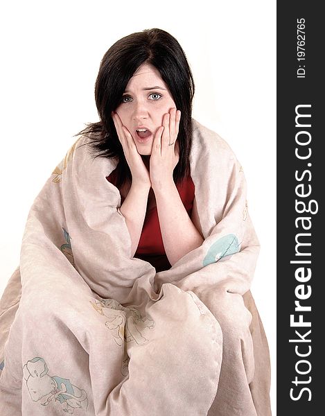 A young girl sitting on the floor covert in a blanket holding her finger to her mouths and thinking hard, for white background. A young girl sitting on the floor covert in a blanket holding her finger to her mouths and thinking hard, for white background.