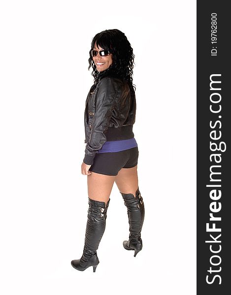 A pretty African American woman in shorts, a leather jacket and boots, standing from the back, for white background. A pretty African American woman in shorts, a leather jacket and boots, standing from the back, for white background.