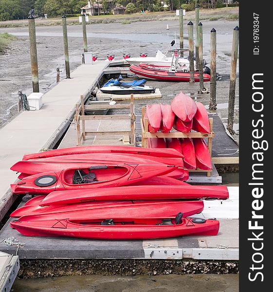 Kayaks stacked on dock at low tide