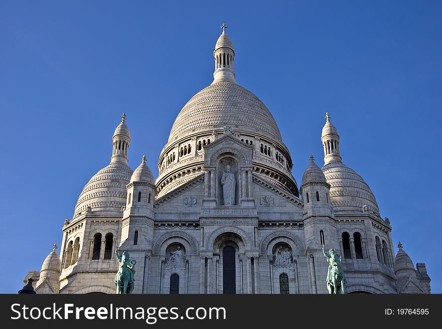 Basilica of Sacre Coeur in Paris. Against the blue clear sky. Urban scene.