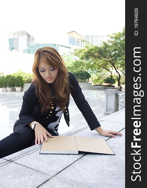 Young beautiful woman reading a book on the stairs