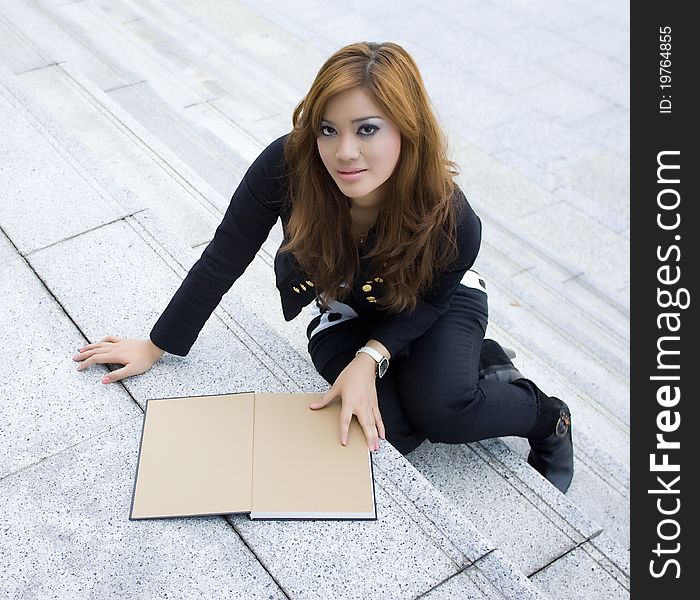 Young beautiful woman reading a book on the stairs. Young beautiful woman reading a book on the stairs