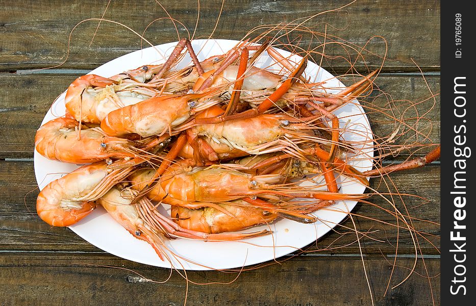 Boiled shrimp on a white plate . Boiled shrimp on a white plate .