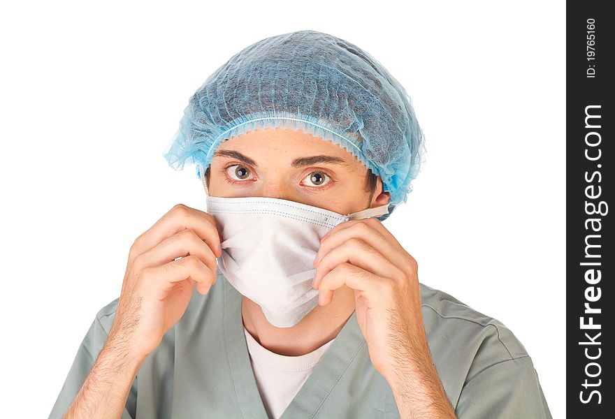 Young doctor wearing mask and medical cap looking at camera