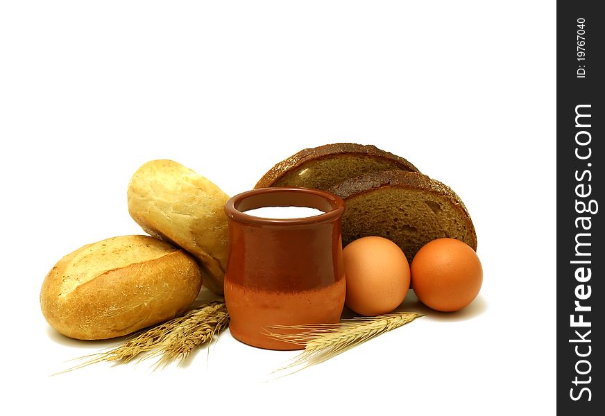 Milk in clay pot, buns, bread and eggs isolated on white background