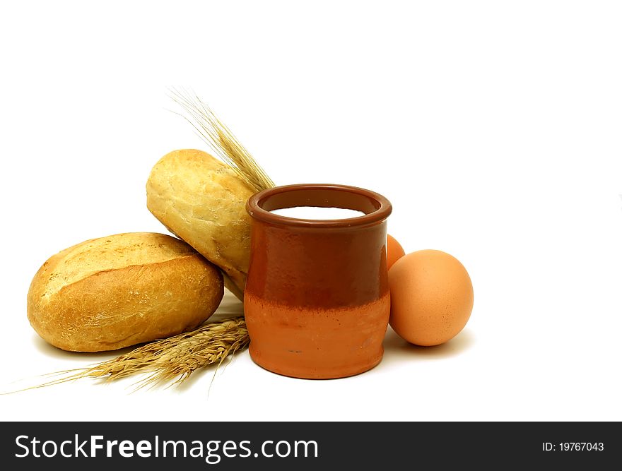 Milk in clay pot, buns and eggs isolated on white background