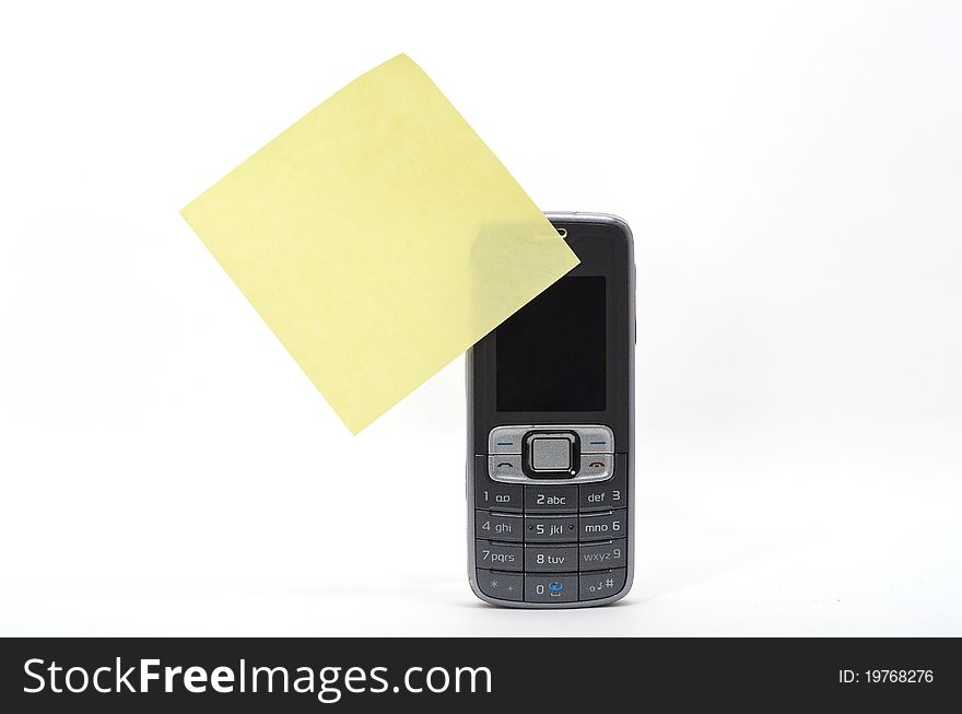 Yellow memo stick to a mobile phone. Yellow memo stick to a mobile phone