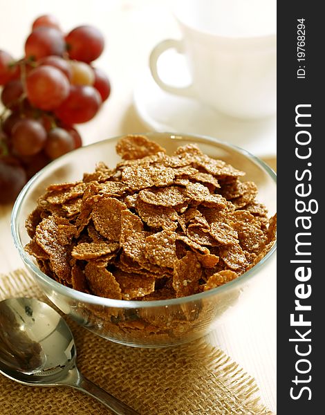 Chocolate muesli in bowl and grapes on table