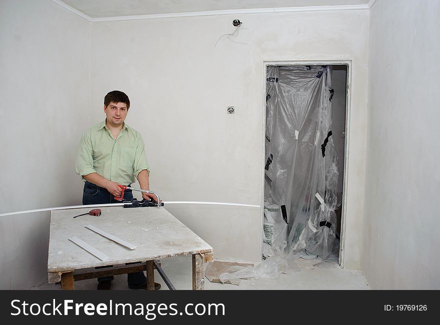 An image of a man making repairs in a room