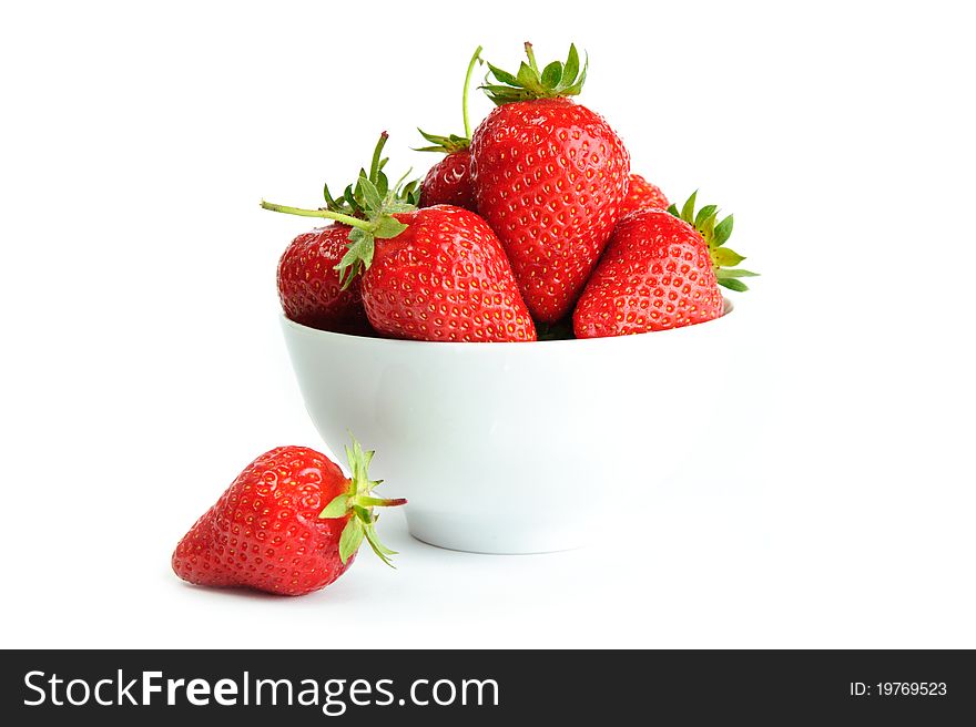 An image of bright red strawberries in a white cup. An image of bright red strawberries in a white cup