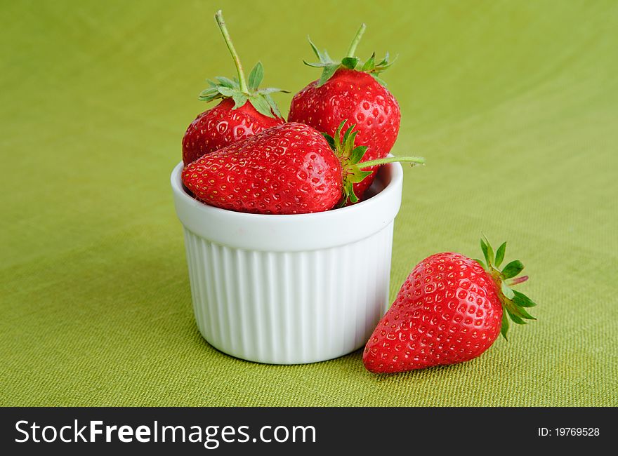 An image of bright red strawberries in a cup