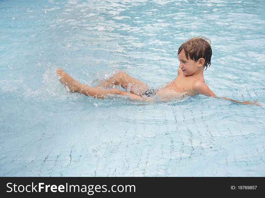 Young boy playing in water pool. Young boy playing in water pool