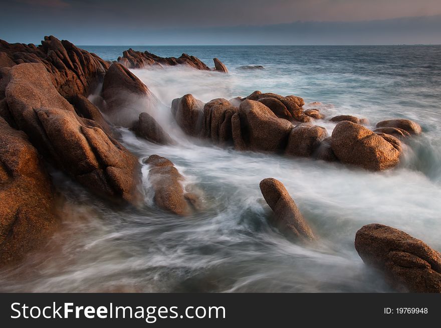 Motion blurred sea on rocky coast