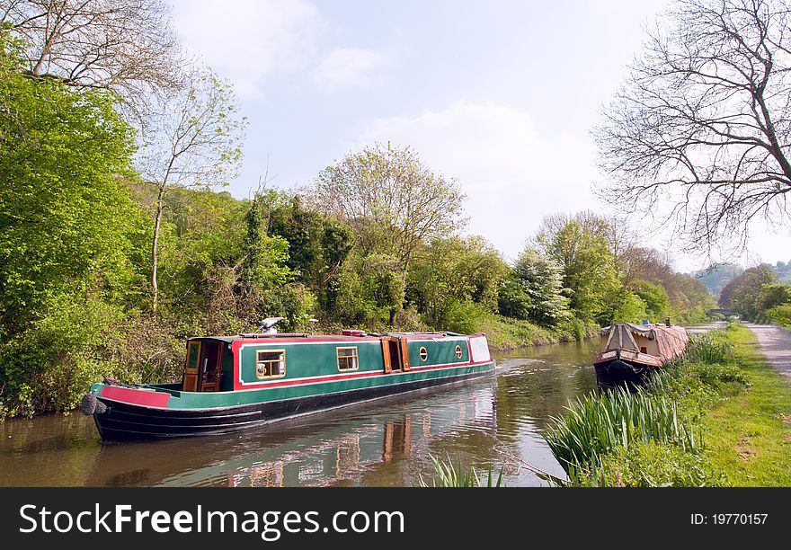 A gaily painted narrrowboat traverses the Kennet and Avon canal, Britain. A gaily painted narrrowboat traverses the Kennet and Avon canal, Britain