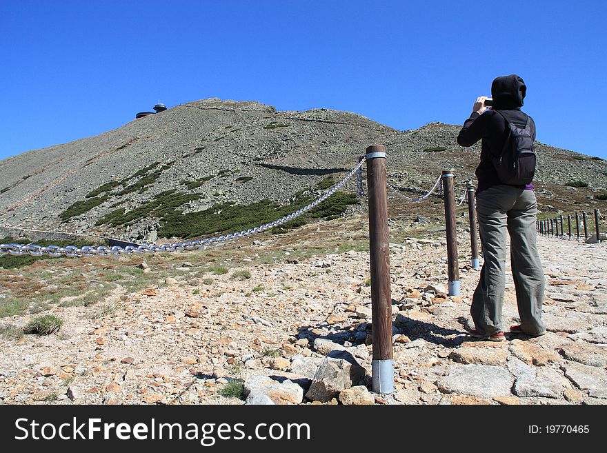 Young traveler takes a photo during a mountain hike. Young traveler takes a photo during a mountain hike.