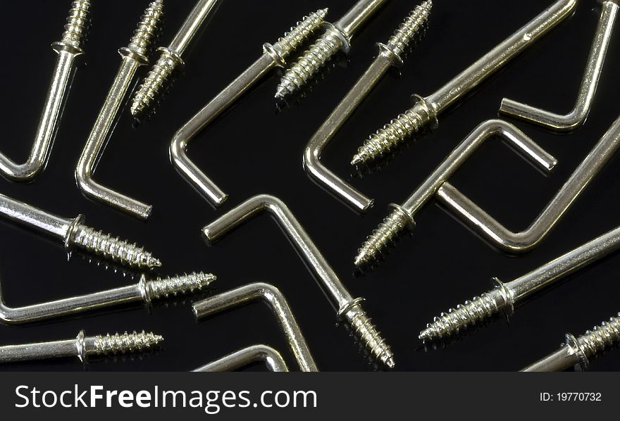 a background of L-shaped metal hooks on a black background. a background of L-shaped metal hooks on a black background