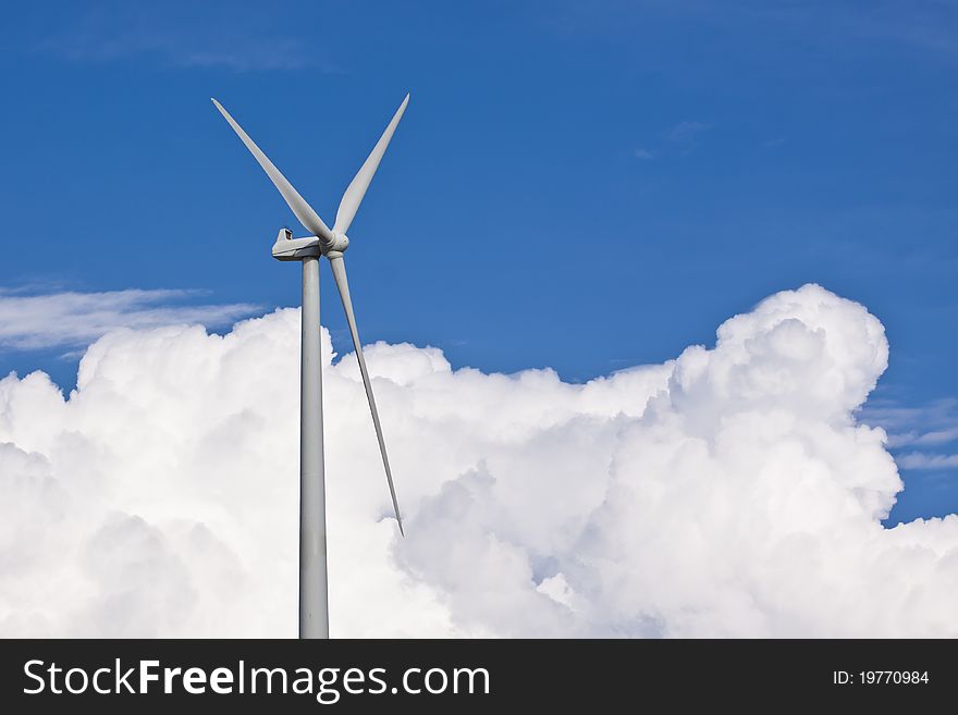 Wind turbine generating electricity with a nice white cloud on the sky