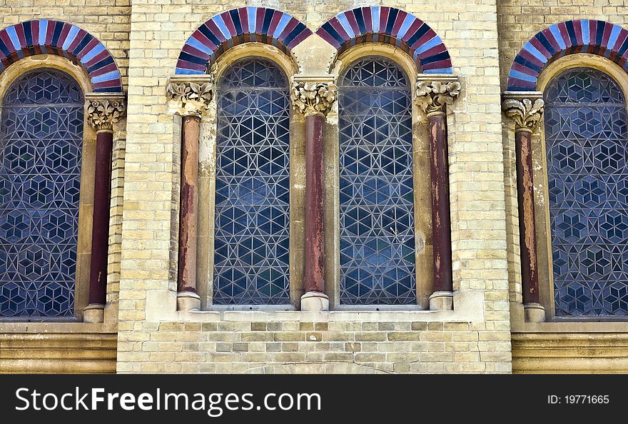 Four arched, leaded church windows with arched tops and pillars