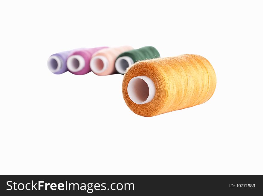 Multi Colored Reels of thread on a white background