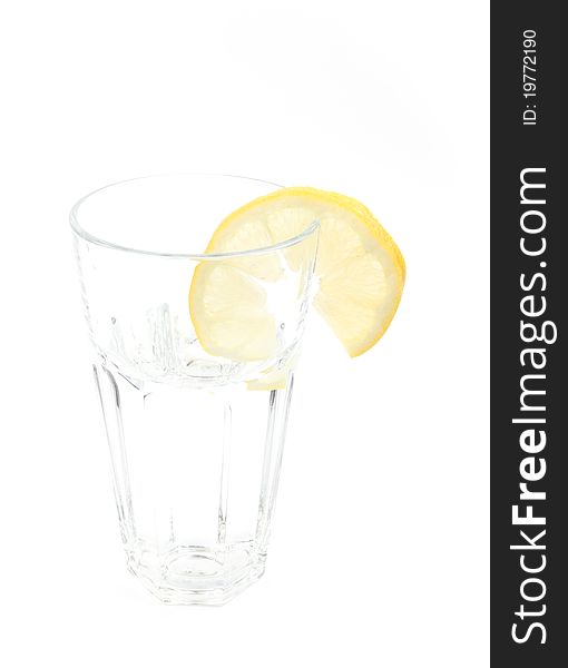 Mineral water in a glass with a lemon on a white isolated background. Mineral water in a glass with a lemon on a white isolated background