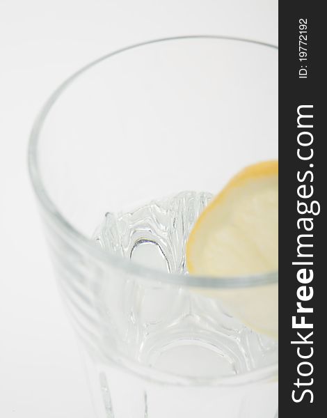 Mineral water in a glass with a lemon on a white isolated background. Mineral water in a glass with a lemon on a white isolated background