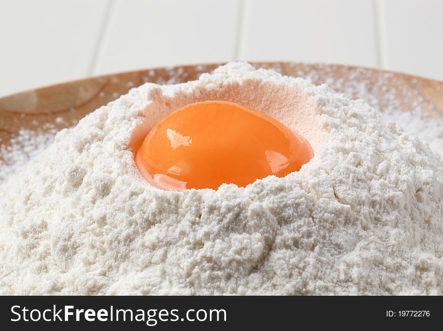 Fresh egg yolk and heap of flour. Fresh egg yolk and heap of flour