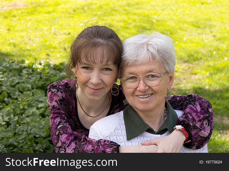 Happy mother and daughter at the park on green grass. Happy mother and daughter at the park on green grass