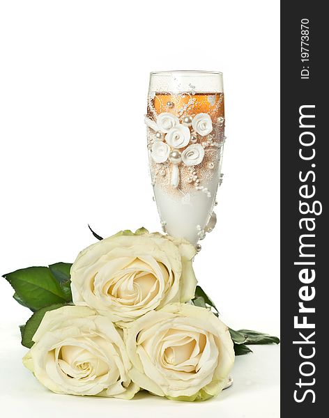 One glass of celebratory champagne with white roses. One glass of celebratory champagne with white roses