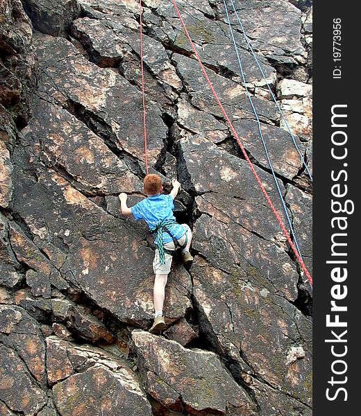 Boy climbing on rope at the rock