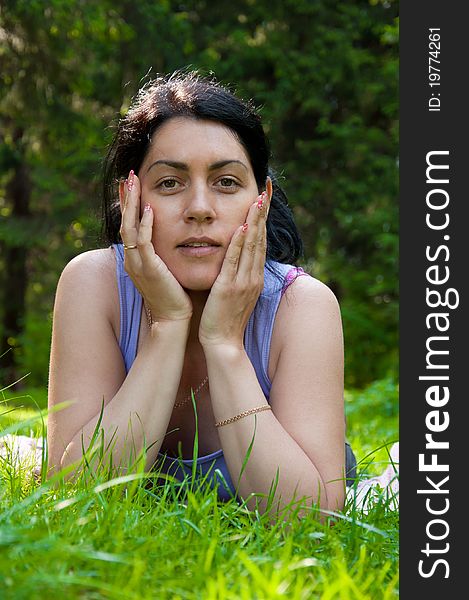 Beautiful middle-aged woman lying on grass