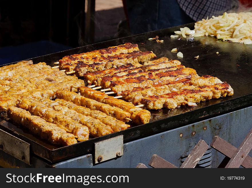 Kebabs being cooked on a barbecue hotplate