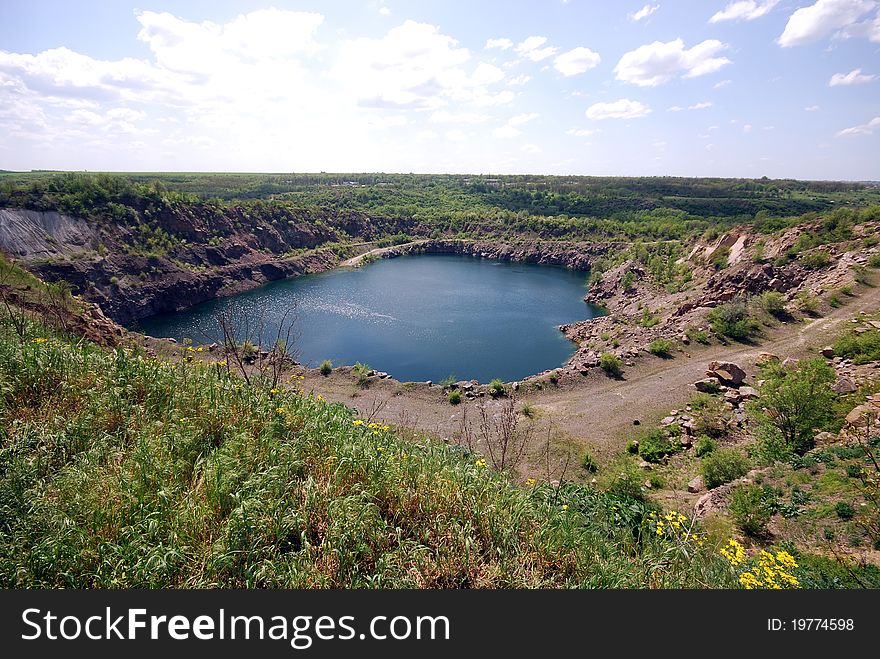 Landscape with blue deep lake in large granite open pit. Landscape with blue deep lake in large granite open pit