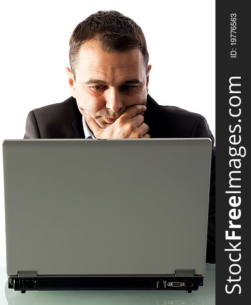Businessman working behind laptop, leaning hand on chin and thinking. Businessman working behind laptop, leaning hand on chin and thinking